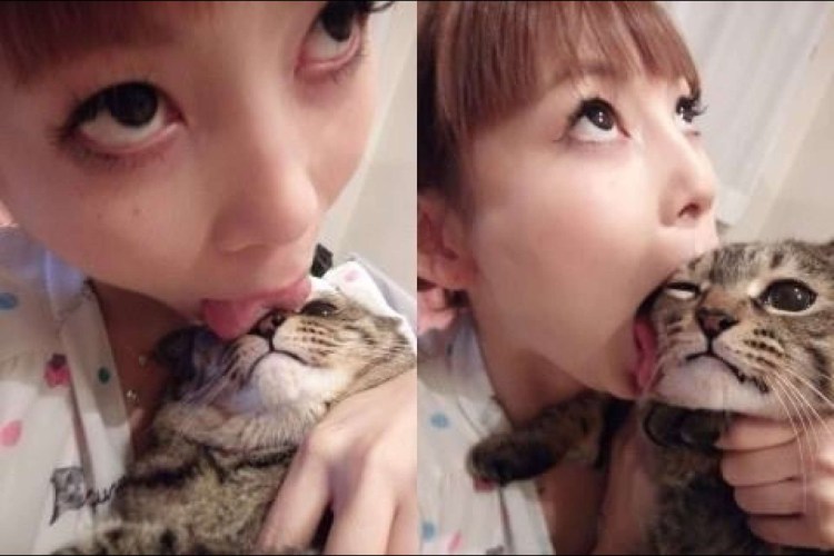 Японка облизывает кота