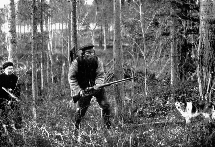 Охотник сидит с ружьем